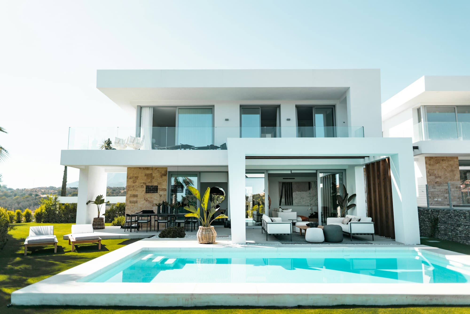 Glass villa opening onto a turquoise pool